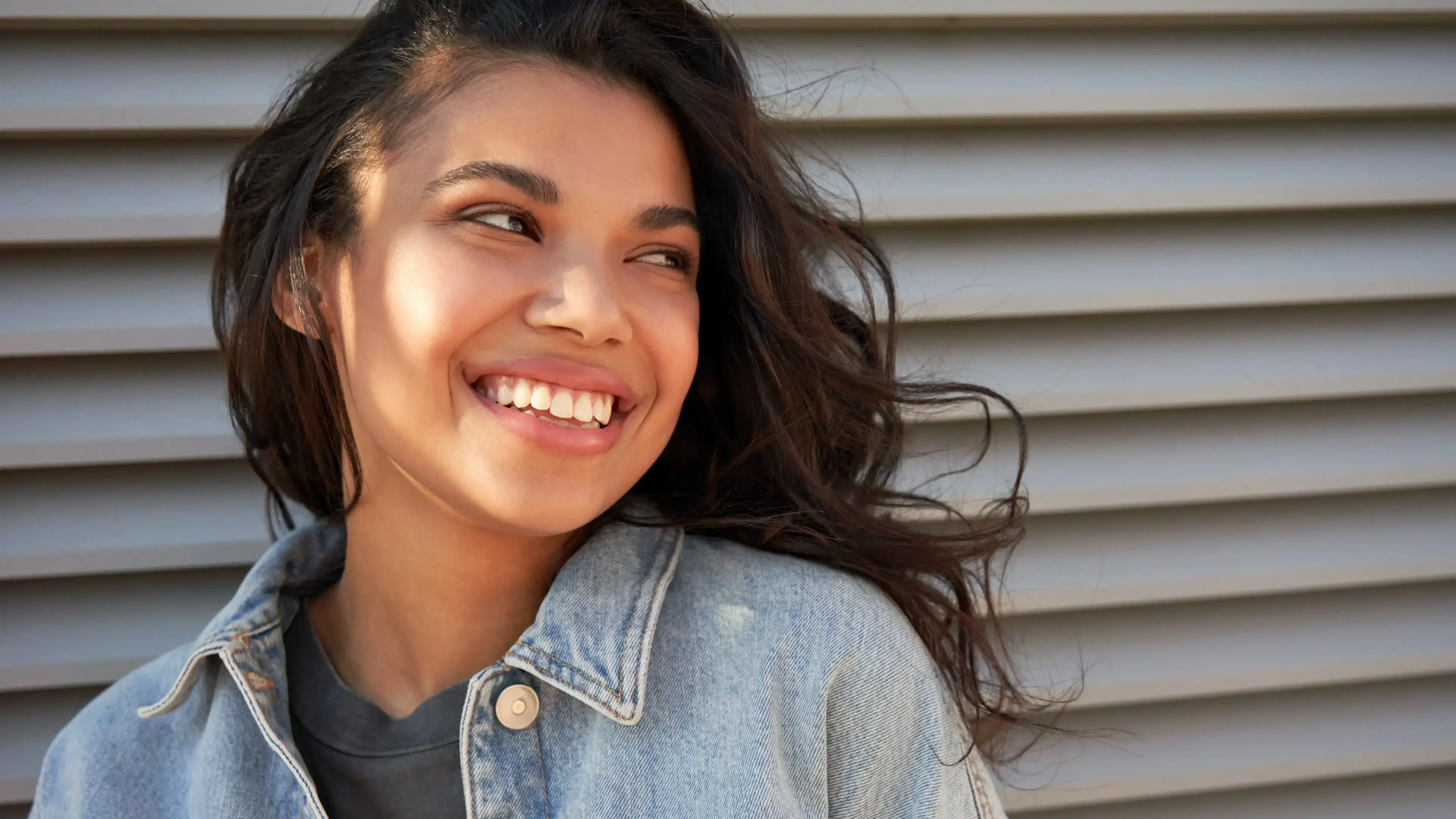 Ein lächelnder, zur Seite schauender weiblicher Teenager