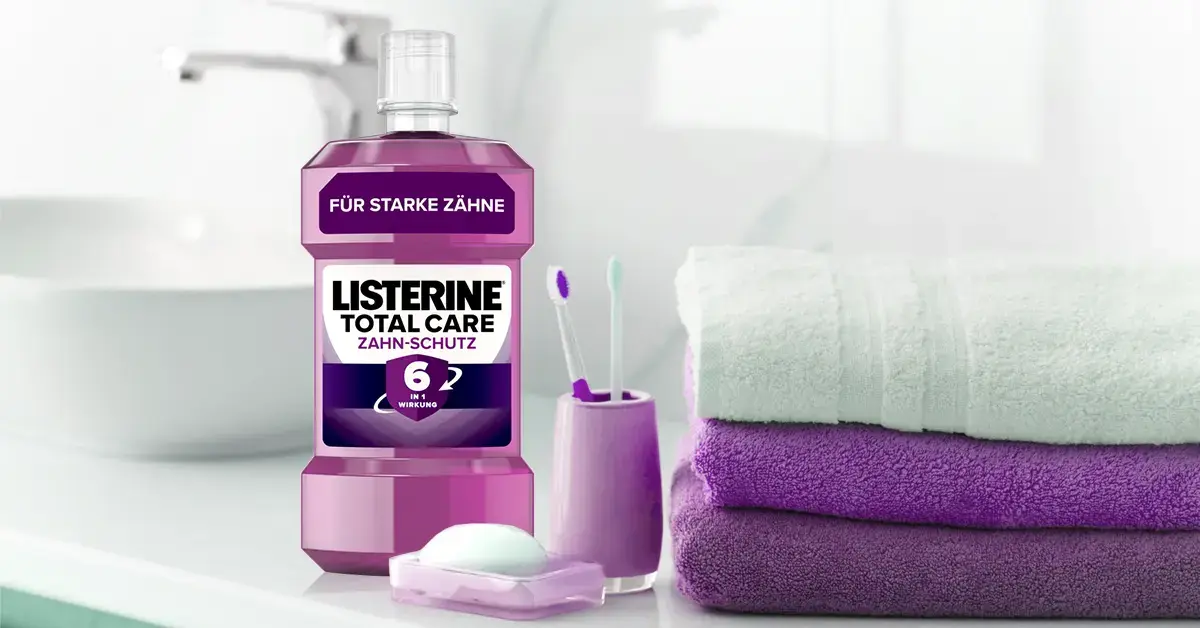 Eine Listerine Packung, zwei Zahnbürsten und drei Handtüchern.