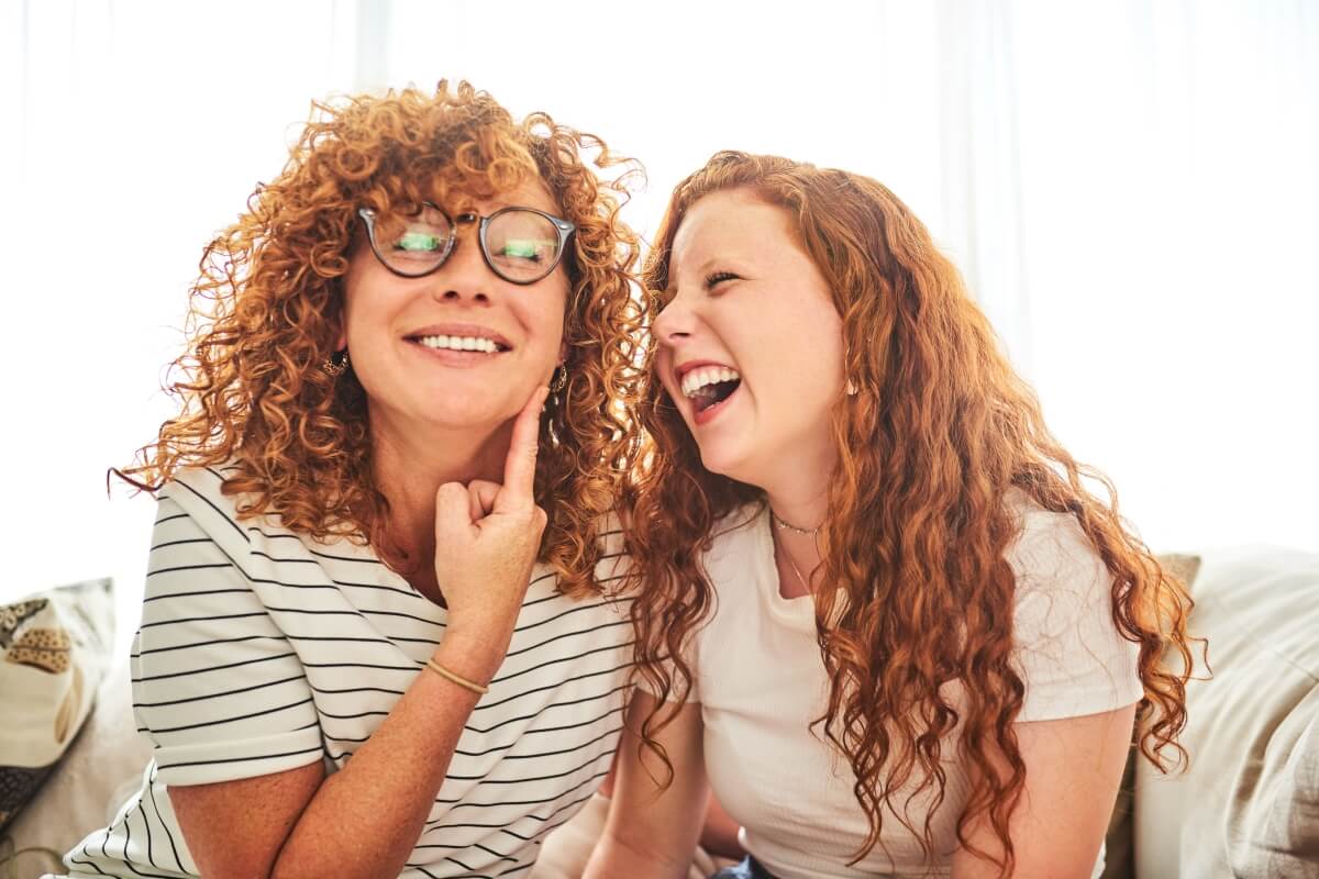 Mère riant avec ses filles à table