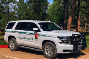 Image of U.S. Park Ranger SUV in front of wooded area