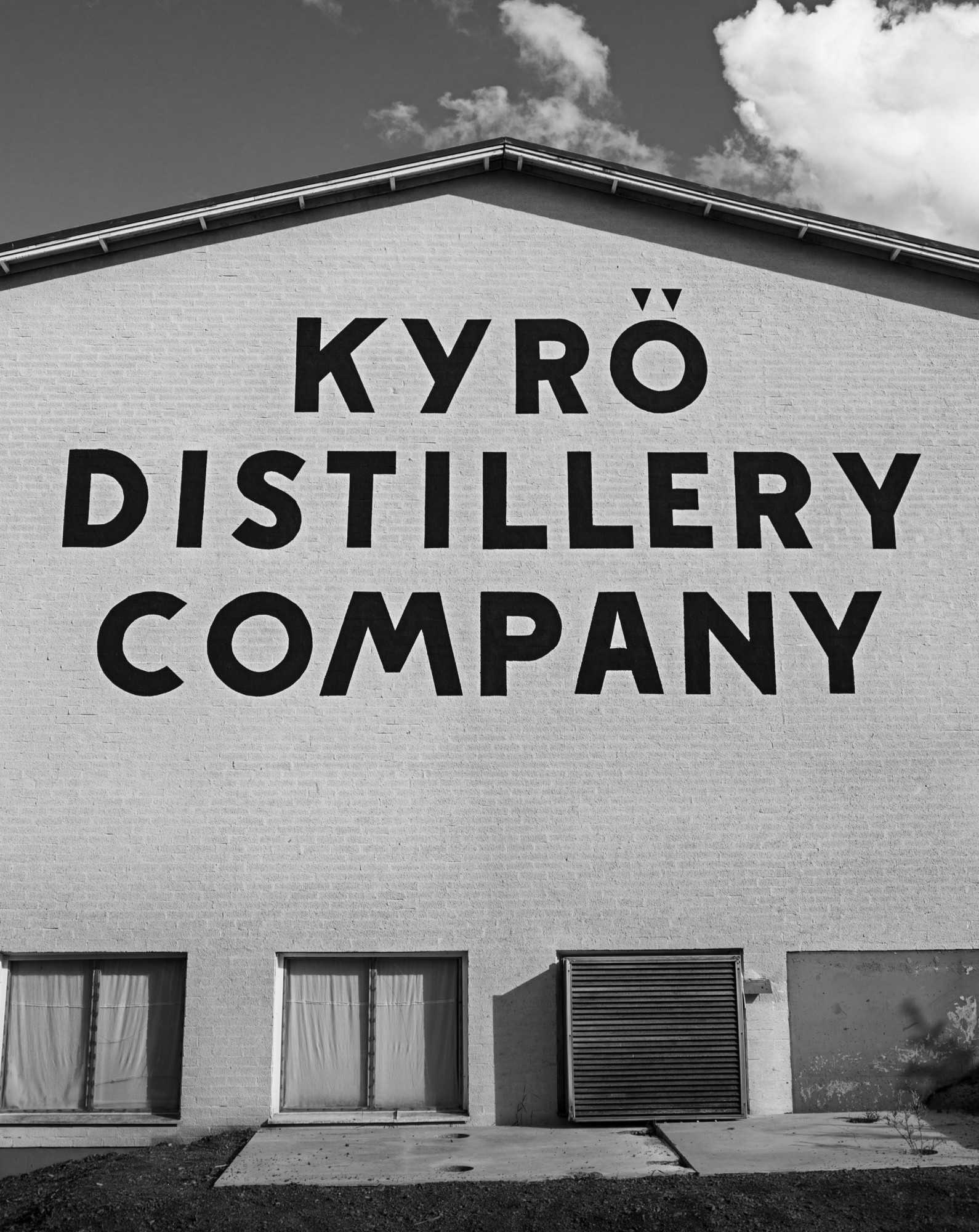 Black and white image of the Kyrö Distillery Company logo on the outside wall of the distillery. 