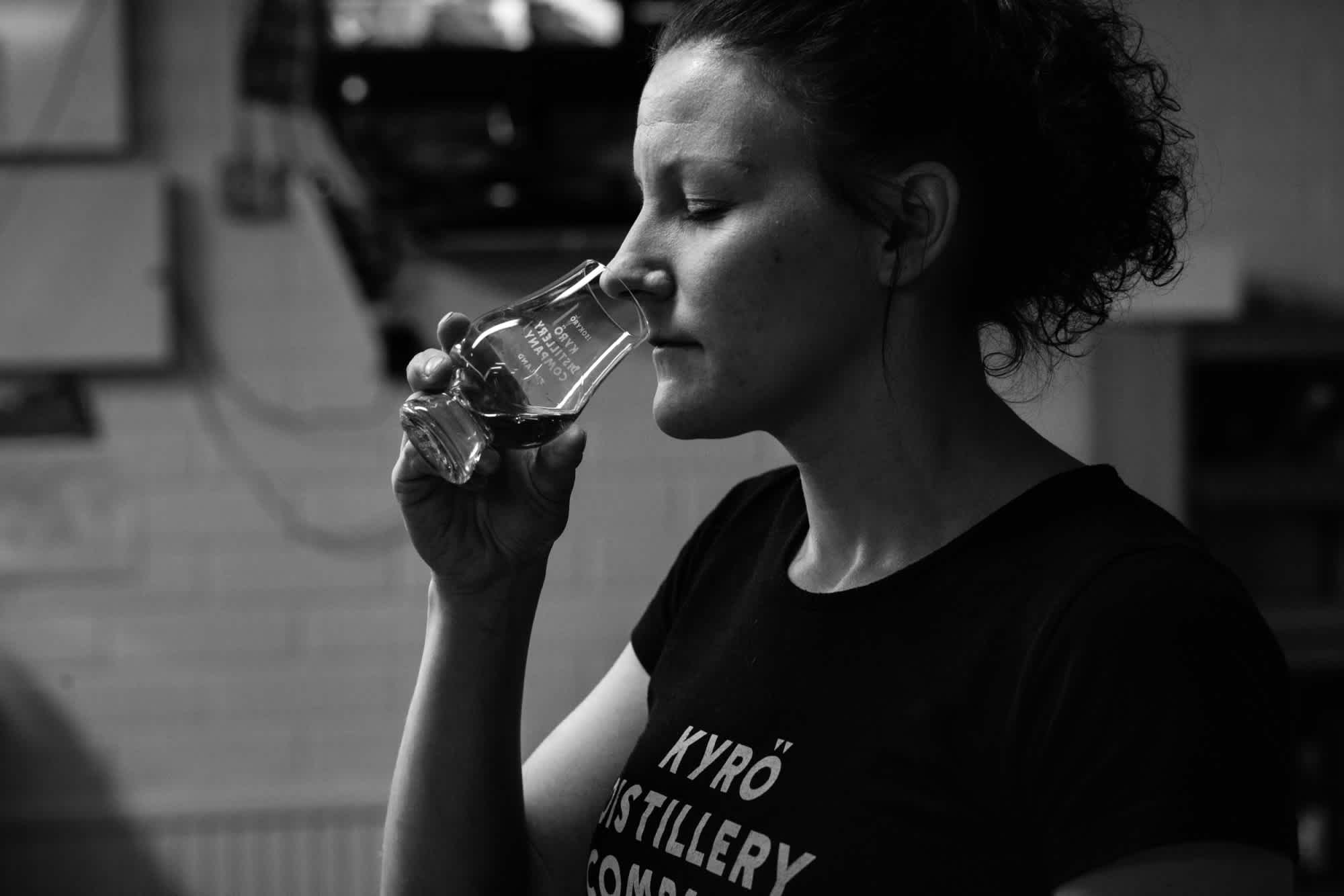 Woman smelling whisky from a glencairn glass in a distillery