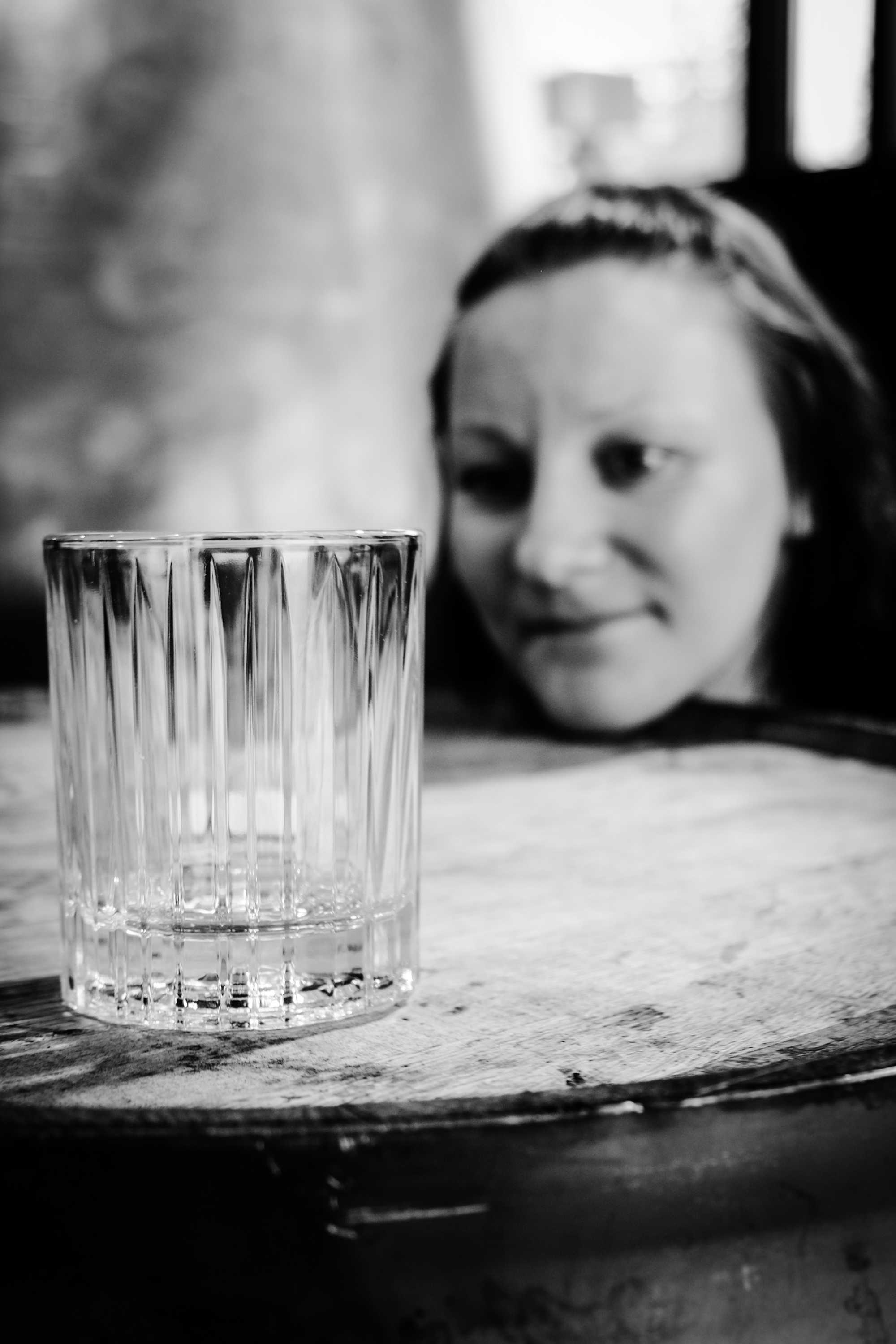 Woman looking at an empty tumbler glass