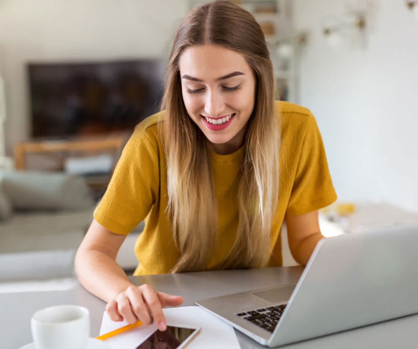 Woman using phone and computer