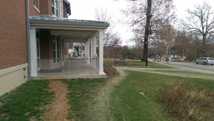Worn footpaths in grass approaching a school