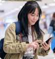 Travel - Woman checking phone in an airport
