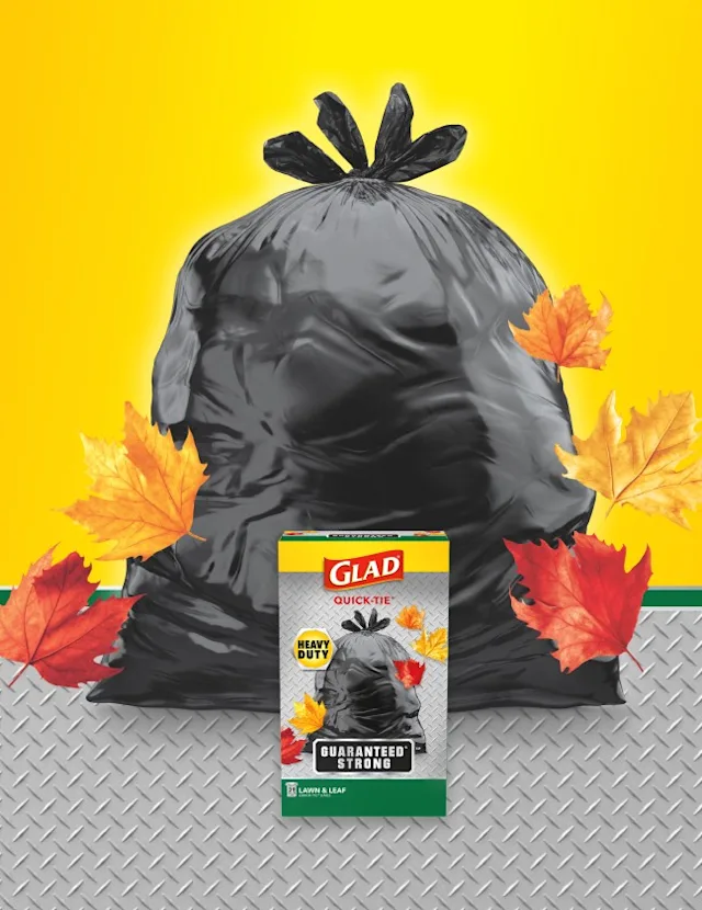 Black bag with yellow and metal textured background, red and yellow leaves and box of Glad bags in front.