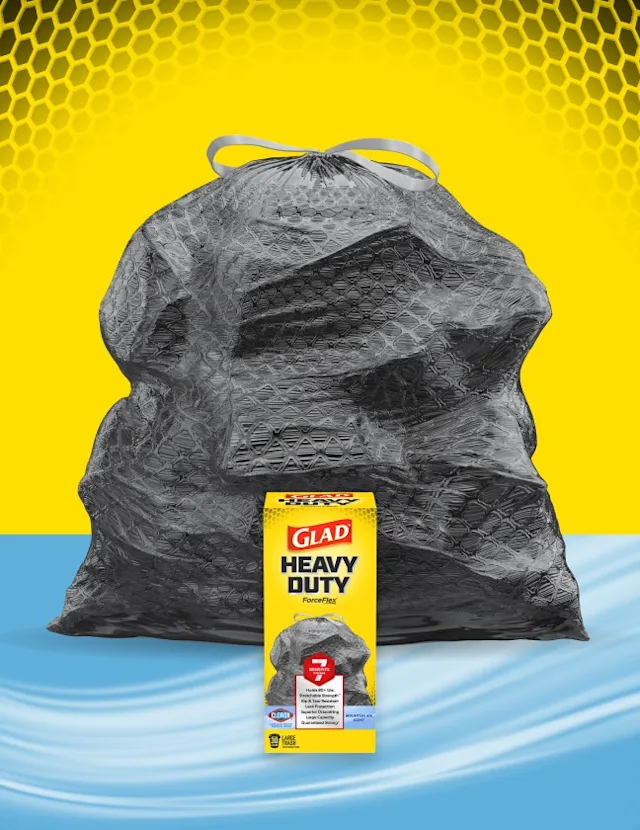 Glad Heavy Duty ForceFlex trash bag with a box of Glad Heavy Duty trash bags in front, against a yellow and blue background.