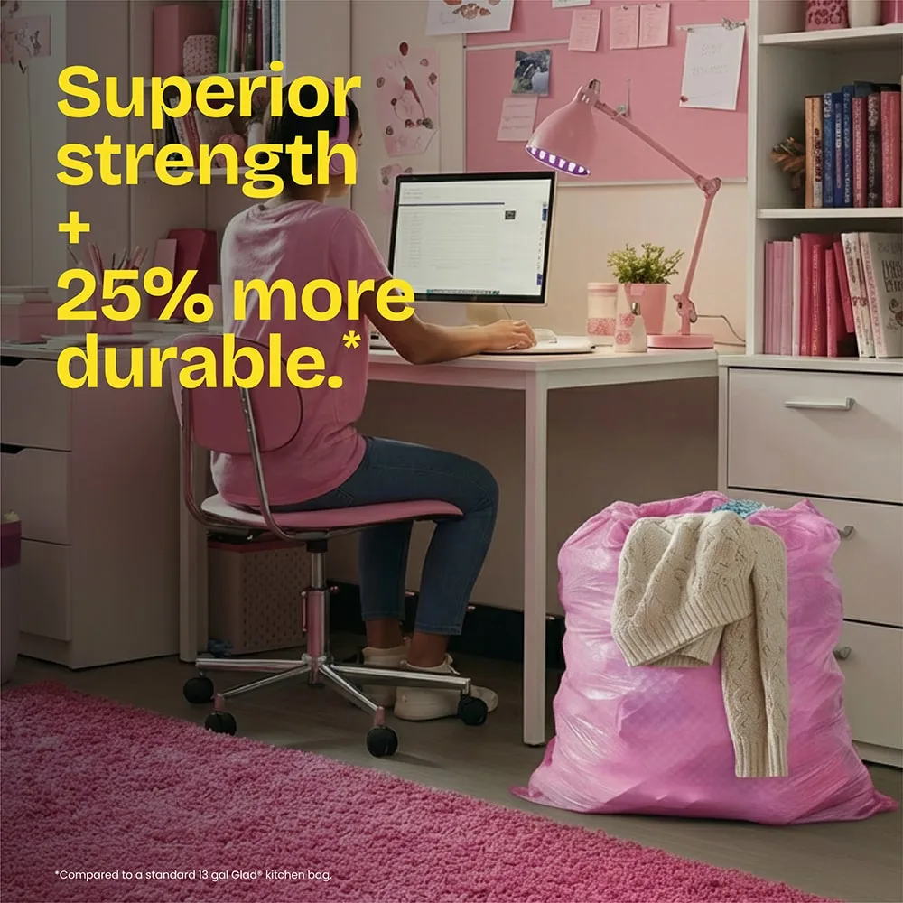 A room decorated with pink accents, a young woman sitting at a desk with a pink trash bag next to her. The words "Superior strength + 25% more durable." in yellow
