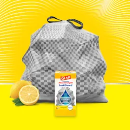 A package of Glad ForceFlex MaxStrength LeakGuard Sunshine Lemon trash bags in front of a gray bag on a yellow background