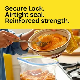 A person spooning mashed sweet potatoes into a zipper bag. The words "Secure lock. Airtight seal. Reinforced strength." in a yellow panel above.