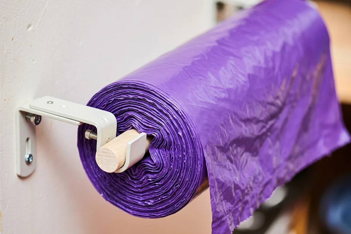 Roll of purple trash bags on a dispenser