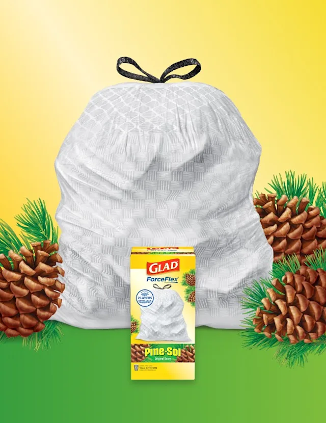 White trash bag with black handles on a yellow and green background surrounded by pine cones. A box of pine-scented trash bags sits in front.