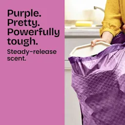 A person stuffing trash into a purple trash bag. Half of the panel is colored purple and has the words "Purple. Pretty. Powerfully tough."