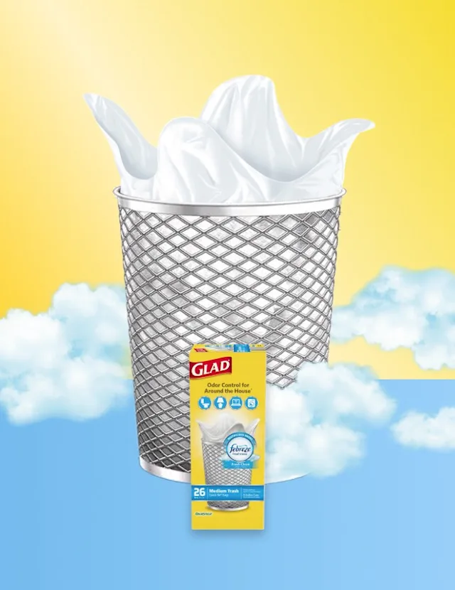 Mesh metal trash can with white bag inside over a yellow and light blue background with clouds, a box of Glad trash bags is in front.