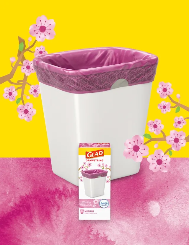 Glad Drawstring Cherry Blossom scented trash bags in a white trash can with pink liner, surrounded by cherry blossom illustrations on a yellow background.