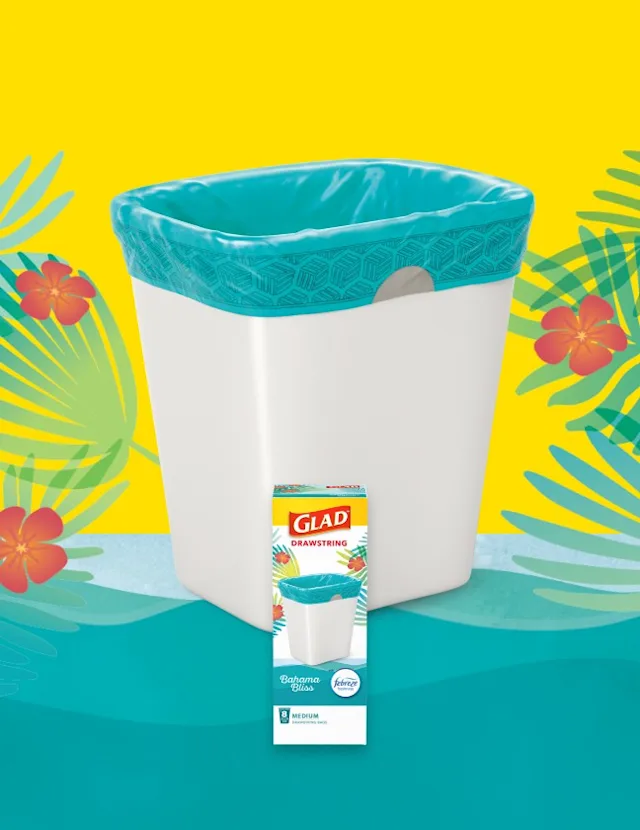 Medium-sized plastic waste basket with teal-colored trash bag inside. Yellow and teal background with red flowers and green fern leaves.