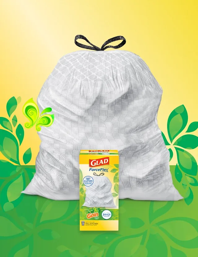 White trashbag with black handles on a background of yellow and green with leaf illustrations. A box of Glad trash bags sits in front.