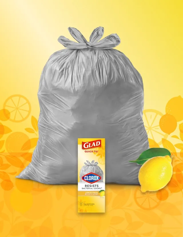 Gray trashbag on yellow background with illustrations of lemons, a package of Glad trashbags in front and a lemon in the lower right corner.