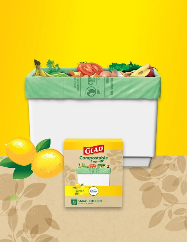 Glad compostable bags with lemon scent, filled with various fruits and vegetables in a white bin against a yellow background