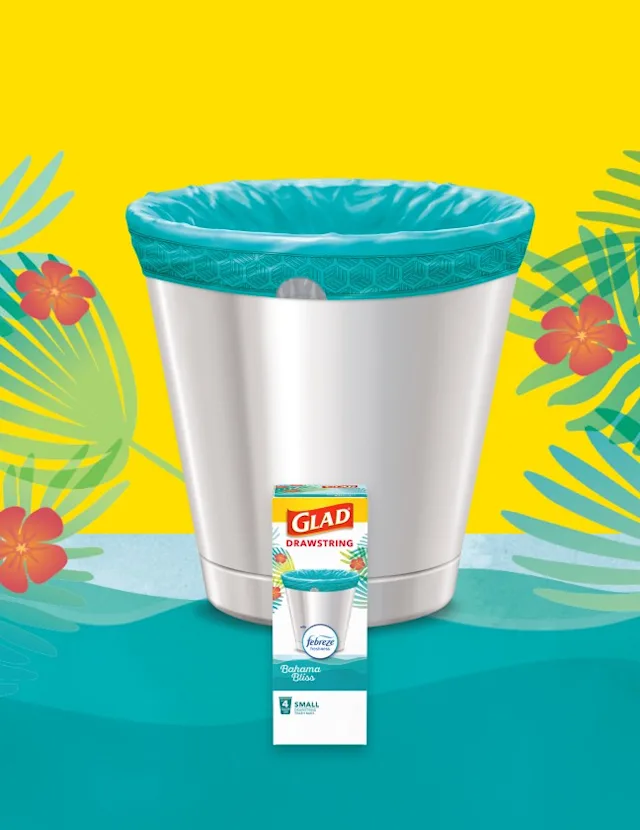 Small metal waste basket with teal-colored trash bag inside. Yellow and teal background with red flowers and green fern leaves.