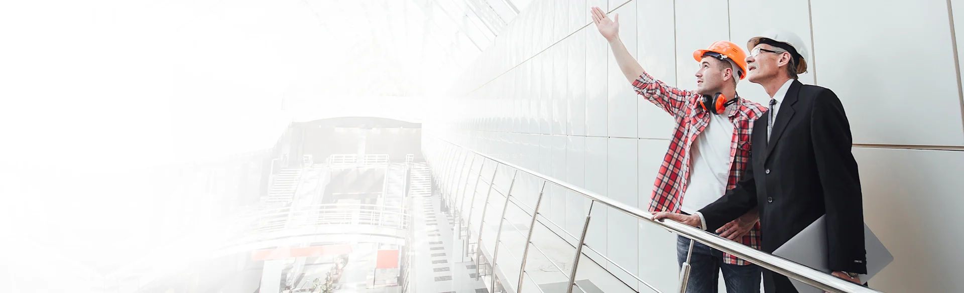 TwoMen-HardHats-Indoors-Pointing HEROImage