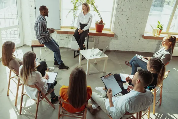 Group of employees listening to two people talk THUMBNAIL