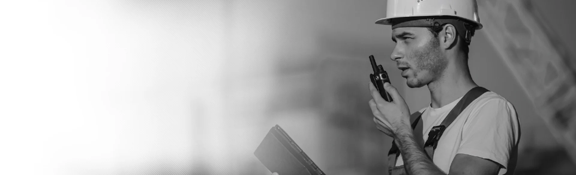 Male construction worker on walkie talkie black and white