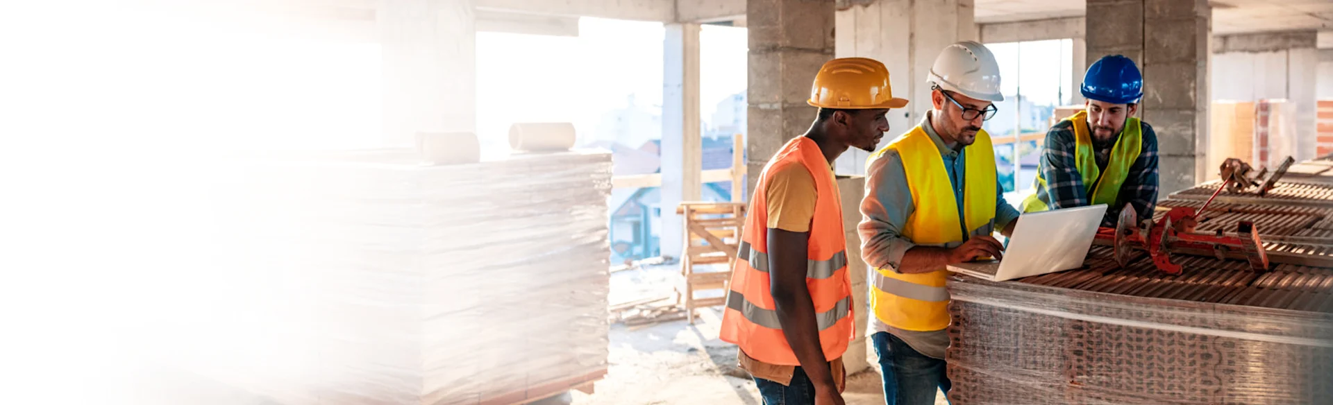 Three construction workers on site looking at an iPad 1200x800