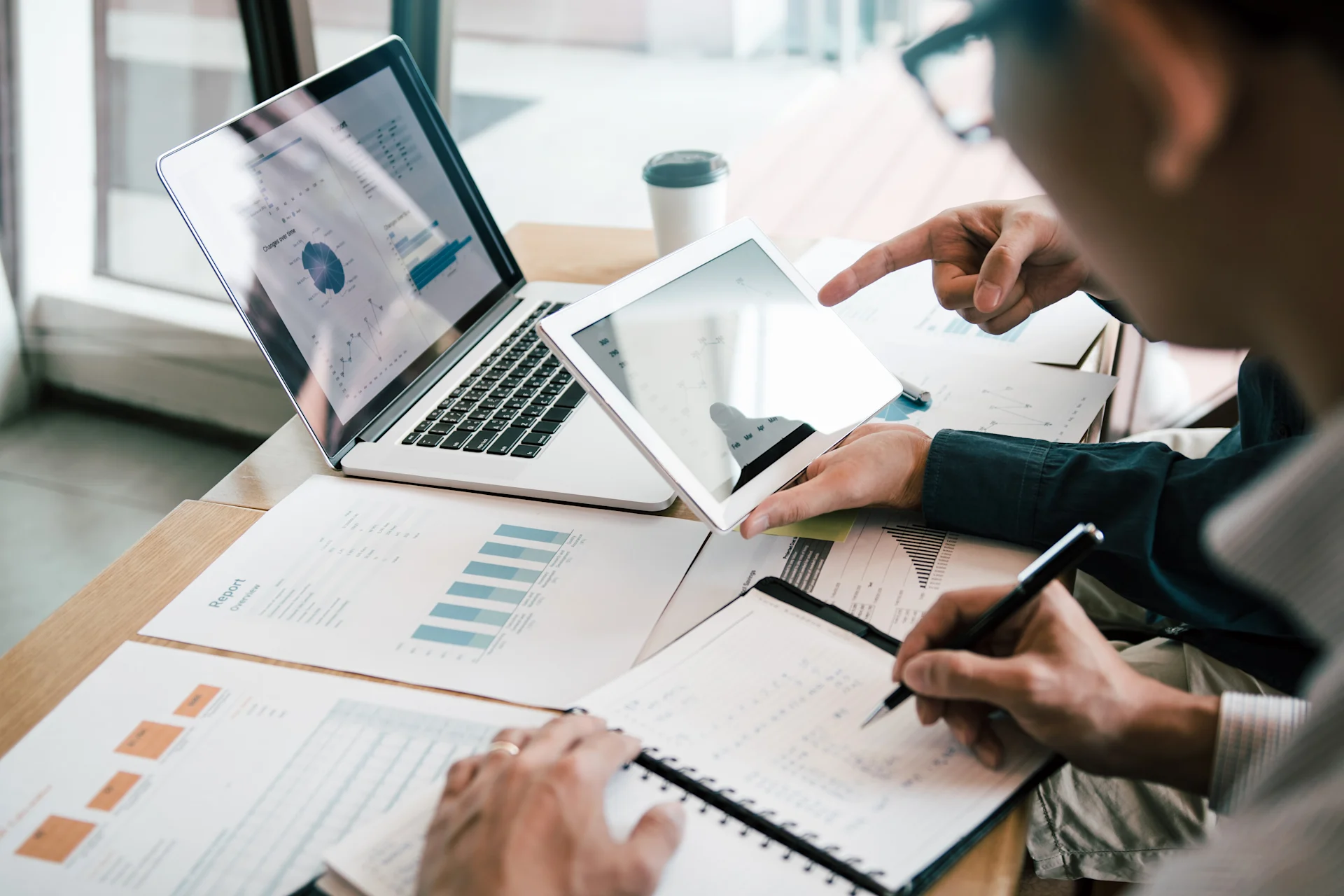 Two executives looking at financial data on a laptop