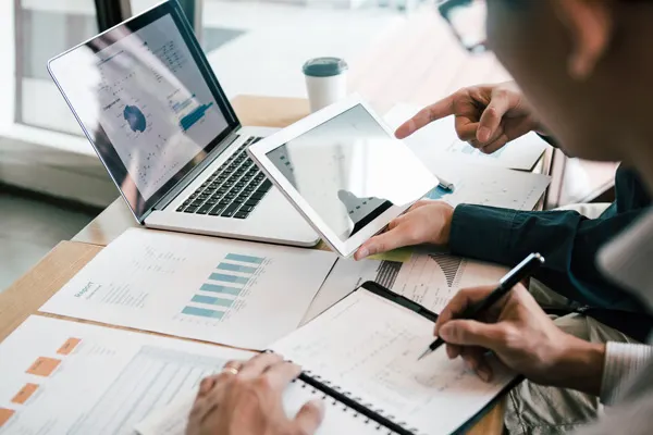 Two executives looking at data on a laptop THUMBNAIL