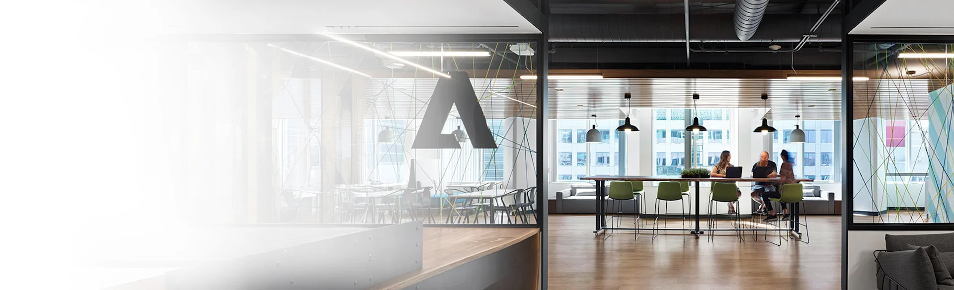 MARANT Adobe Systems Inc Canada - three employees talking at a desk in the distance