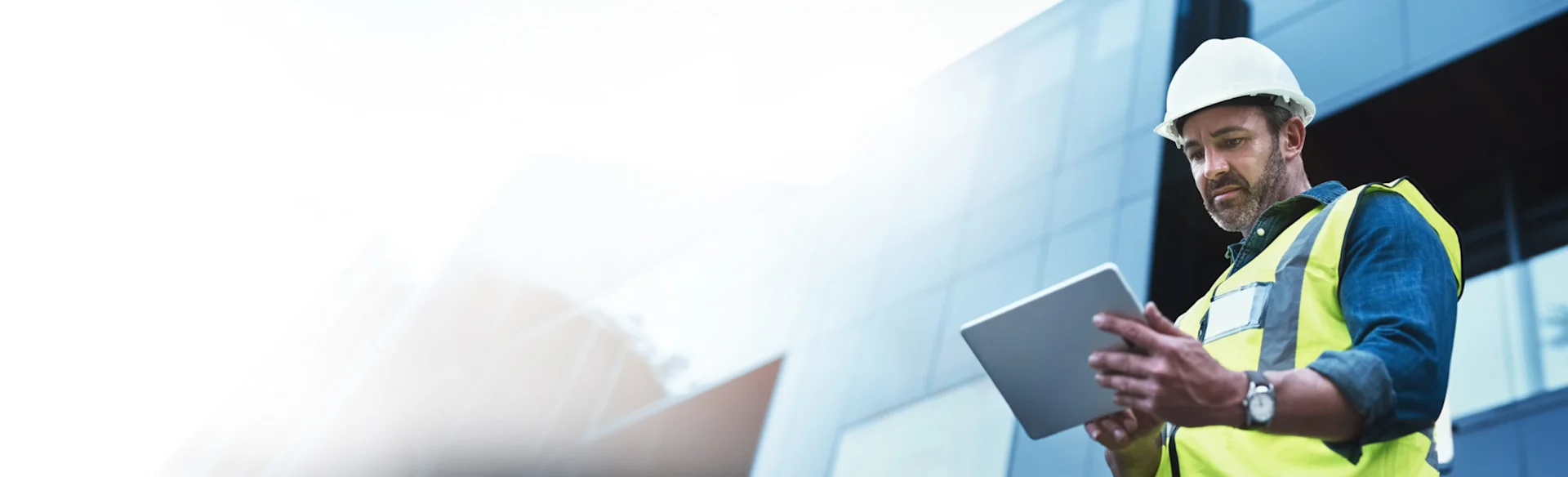 Male construction worker looking at an iPad 1200x631