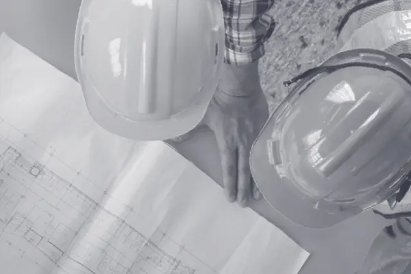 Over head shot of two construction workers looking at a drawing black and white THUMBNAIL