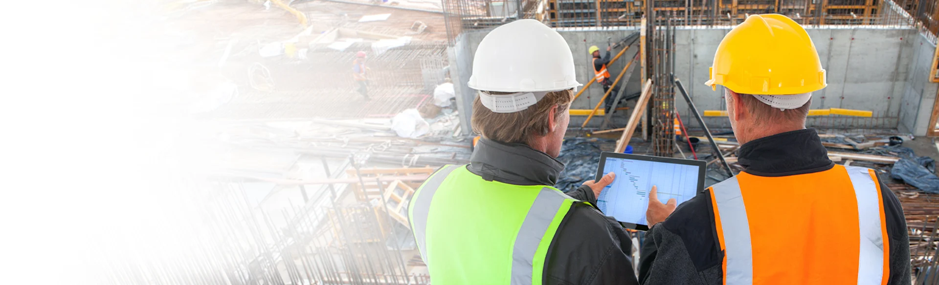 Two construction executives at a construction site looking at an iPad