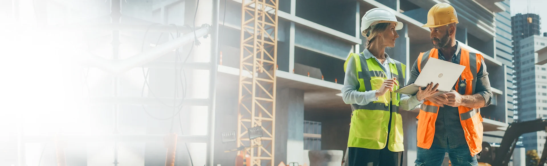 Man Woman Outdoors on a construction site looking at a laptop HEROImage