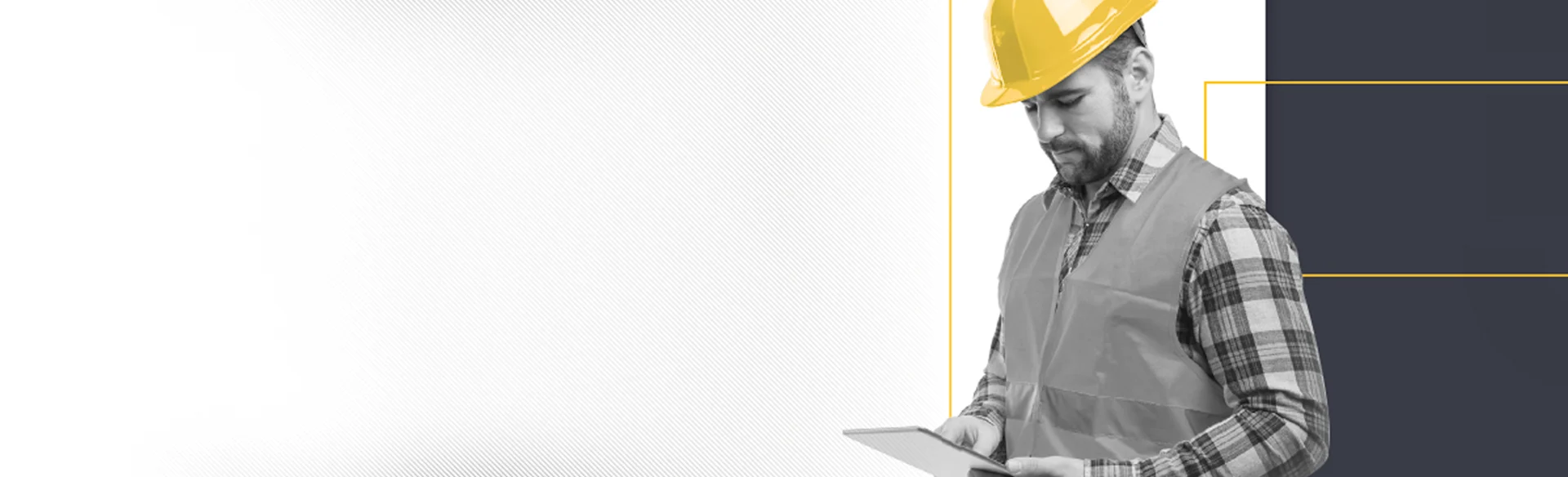 Male construction worker wearing yellow helmet looking at an iPad - black and white and yellow