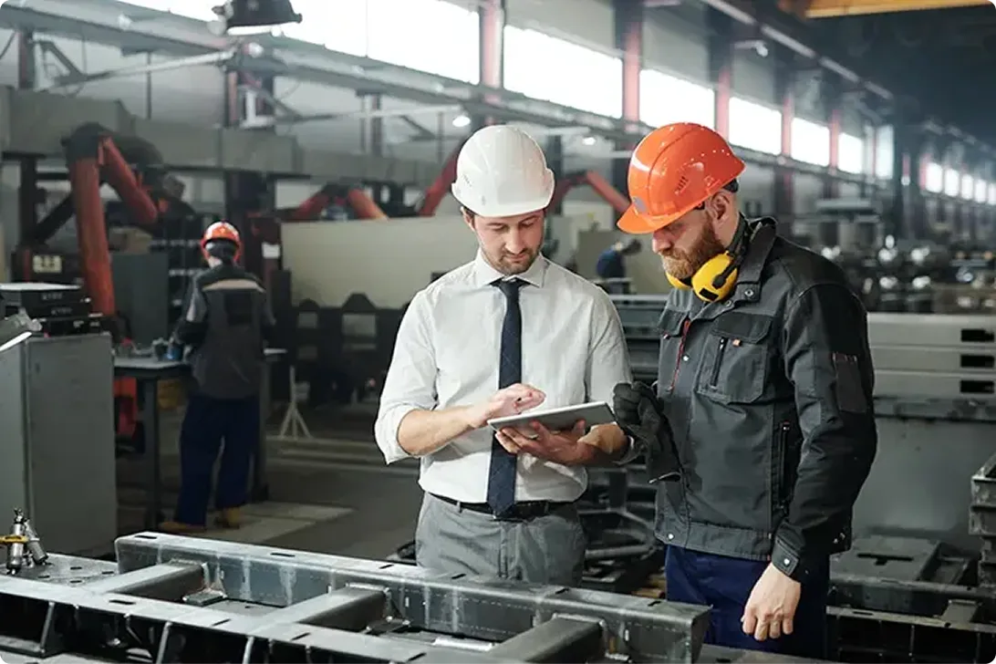 Two male construction workers looking at an iPad