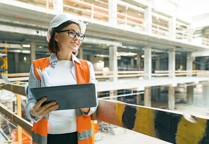 Female executive wearing helmet holding tablet