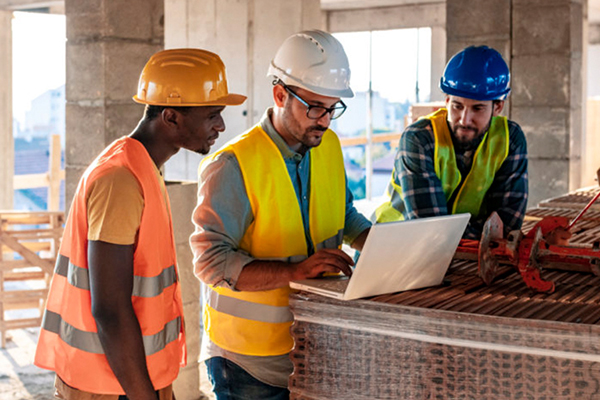 Three construction workers on site looking at an iPad THUMB