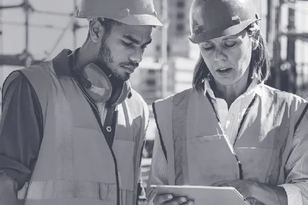 Three construction workers on site looking at an iPad THUMBNAIL