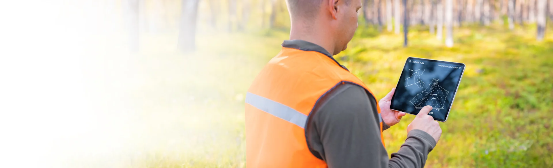 Over the shoulder shot of construction worker looking at an iPad