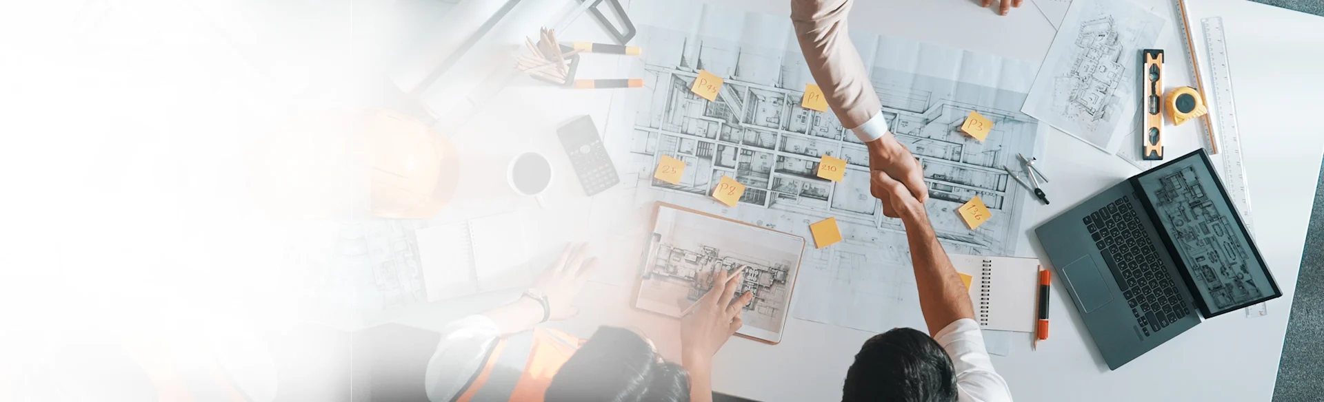 Construction-workers-shaking-hands-Indoors-Laptop HEROImage