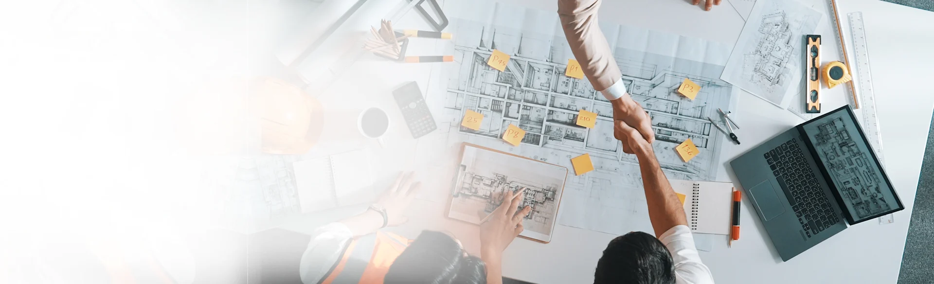 Construction-workers-shaking-hands-Indoors-Laptop HEROImage