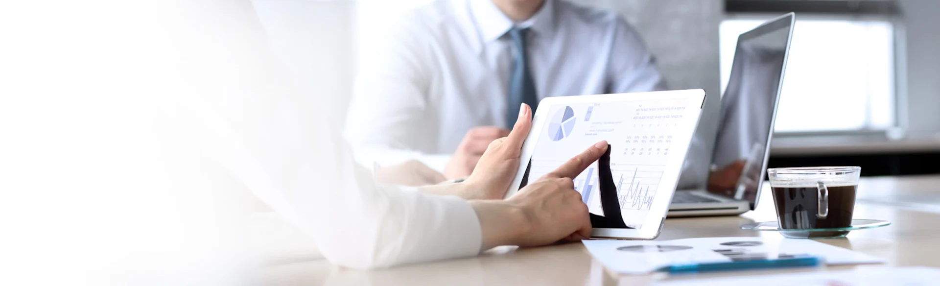 Graphs and charts on an iPad and papers on a desk 1200x800