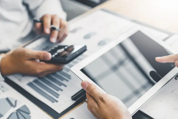 Two accountants looking at charts and an iPad THUMBNAIL