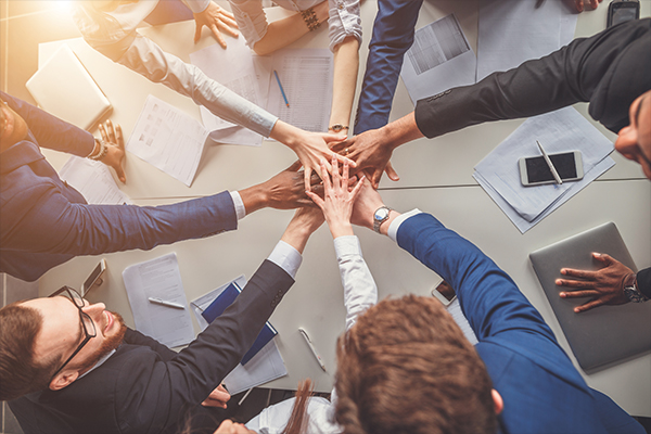Office team putting their hands in the middle