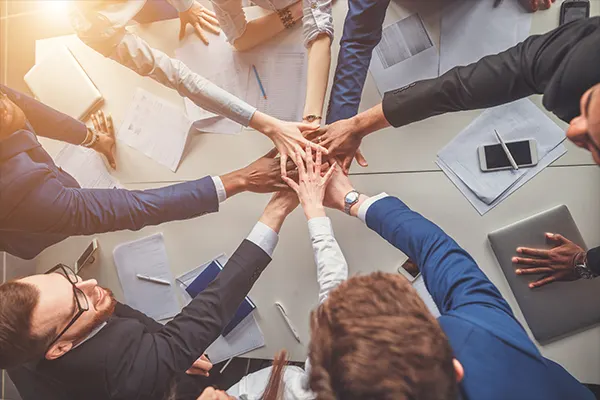 Office team putting their hands in the middle