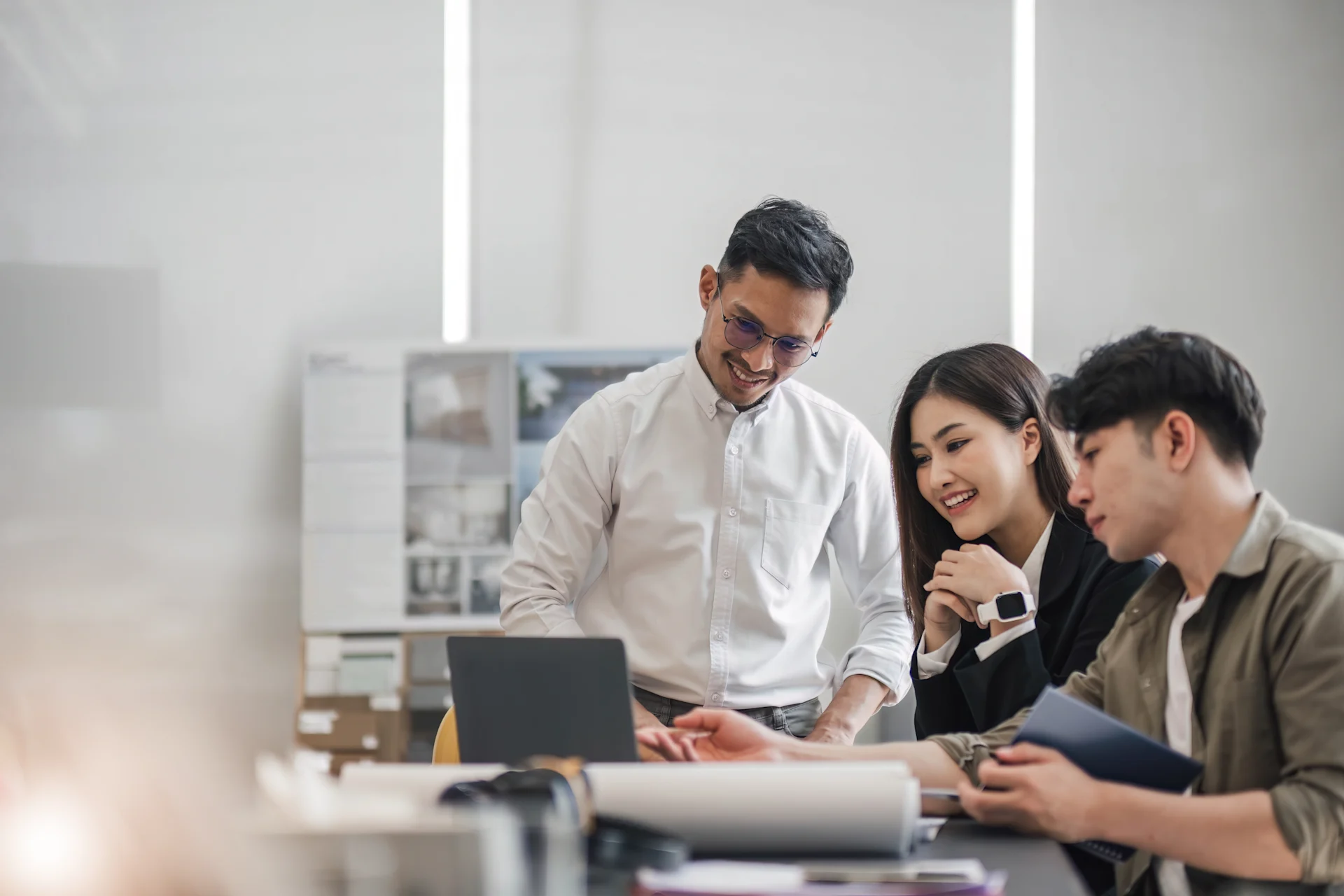 Three employees standing looking at an iPad