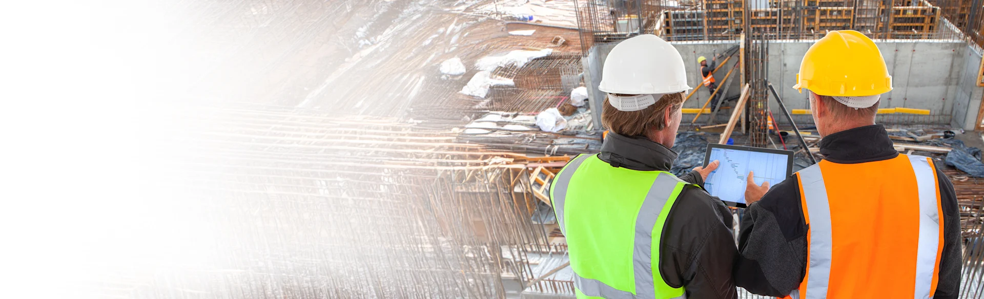 Two construction workers looking at an iPad
